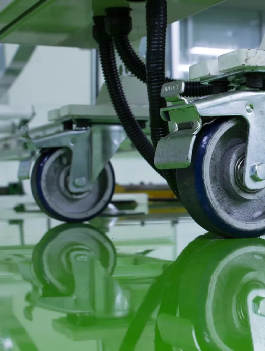 Heavy-duty caster wheels on a reflective green epoxy-coated industrial floor