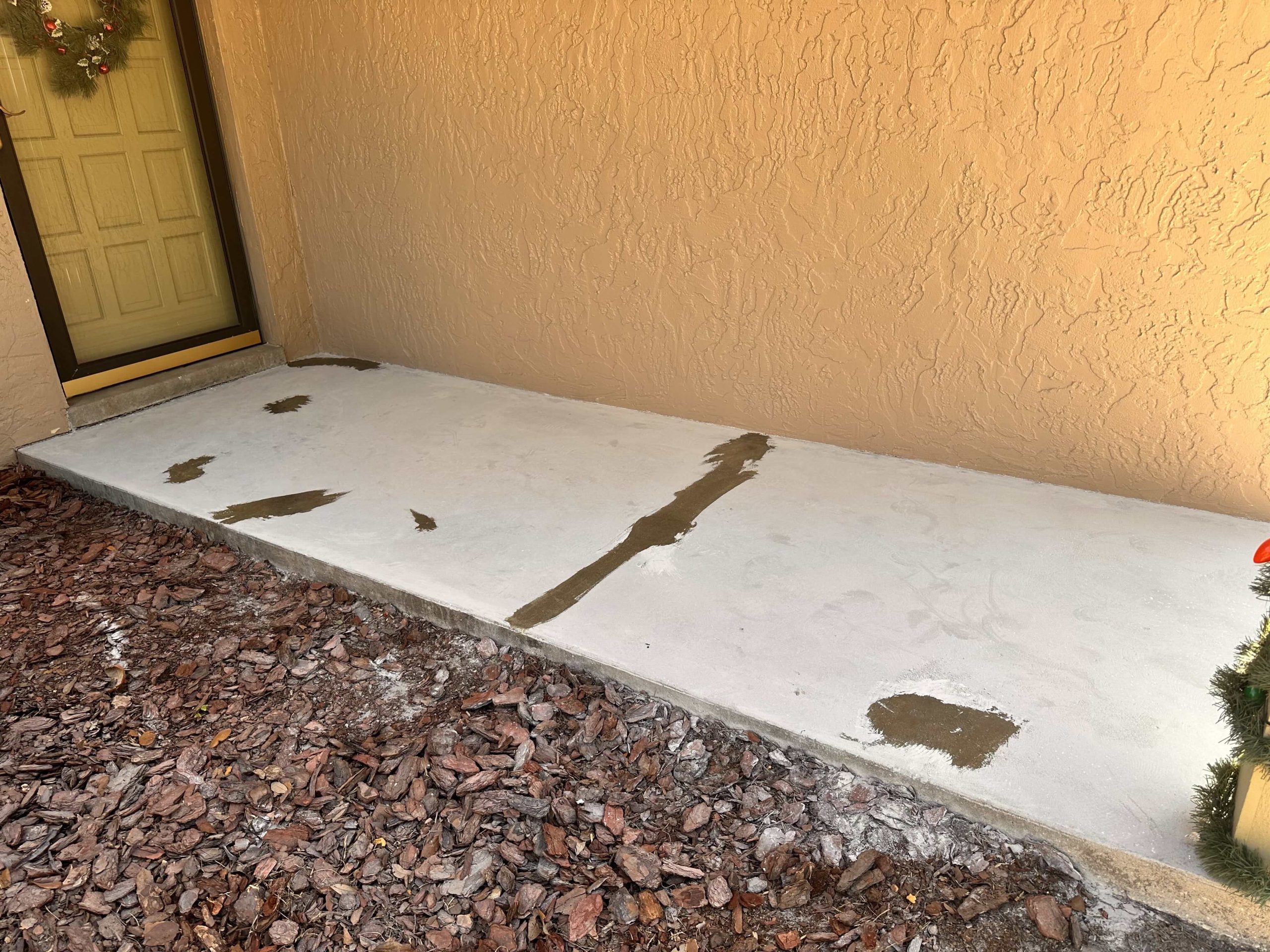 Front porch with visible cracks and stains before surface repair