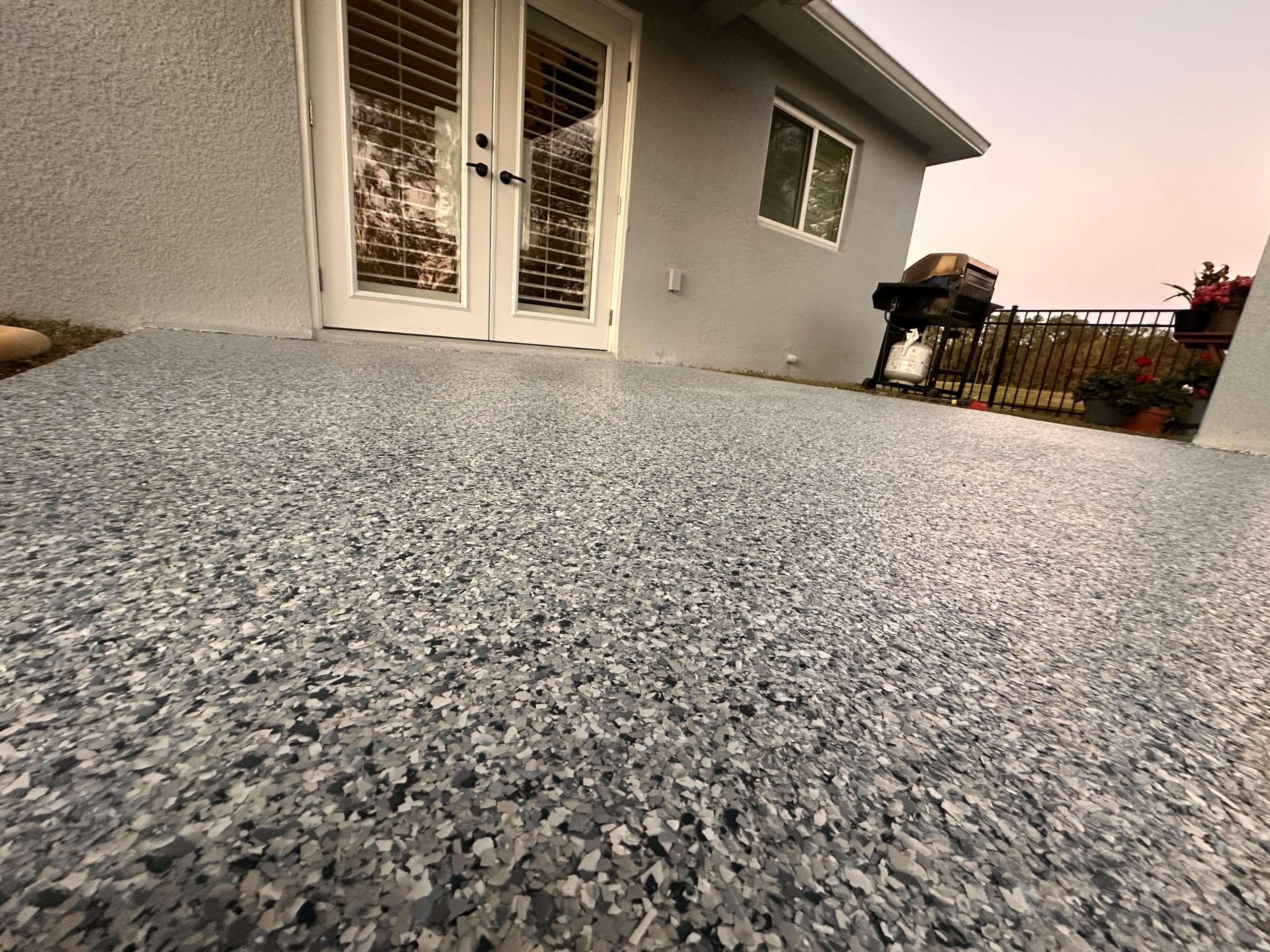 Finished epoxy flake coating on residential outdoor patio.