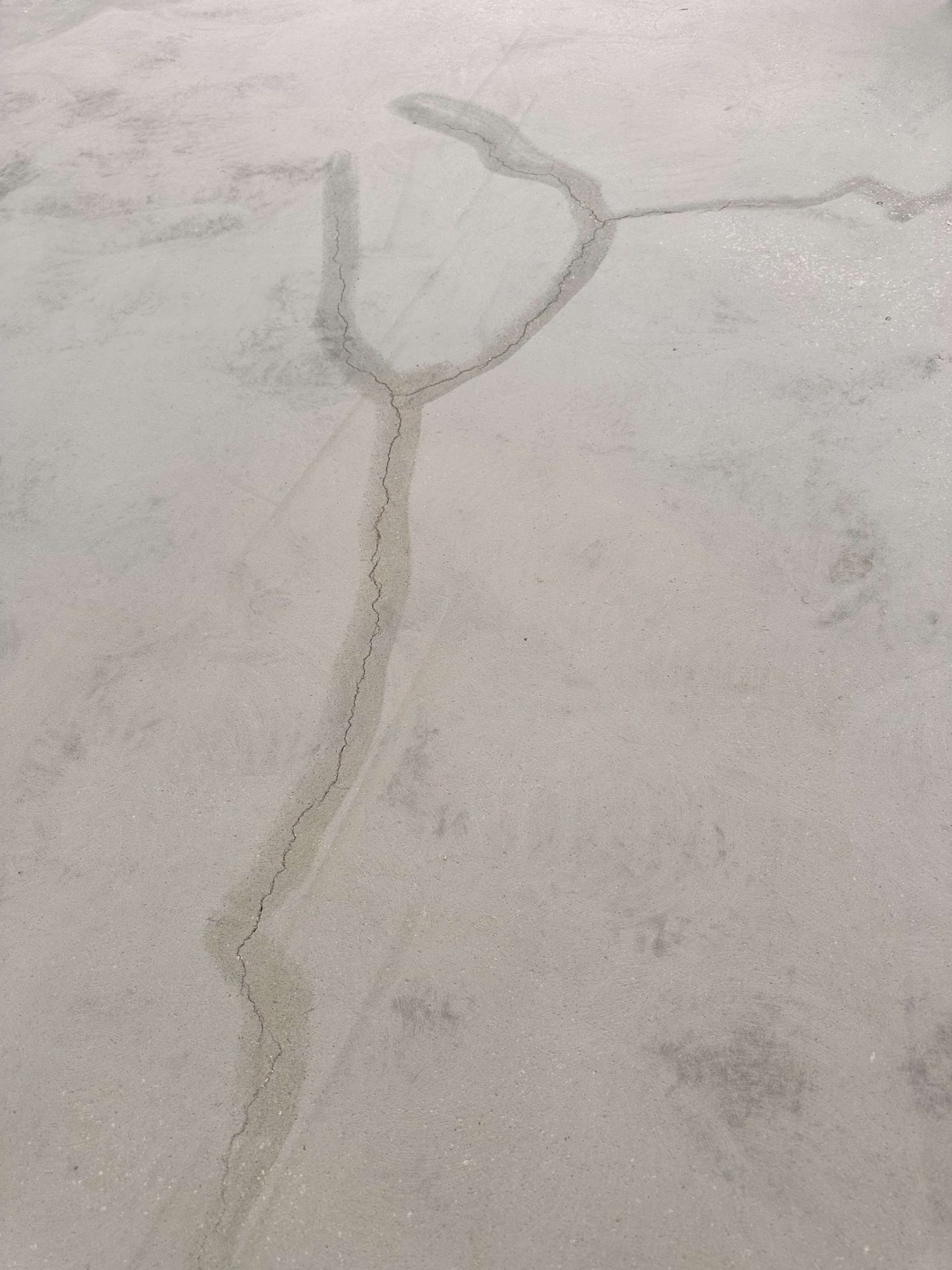 Close-up of crack repair lines on a concrete garage floor
