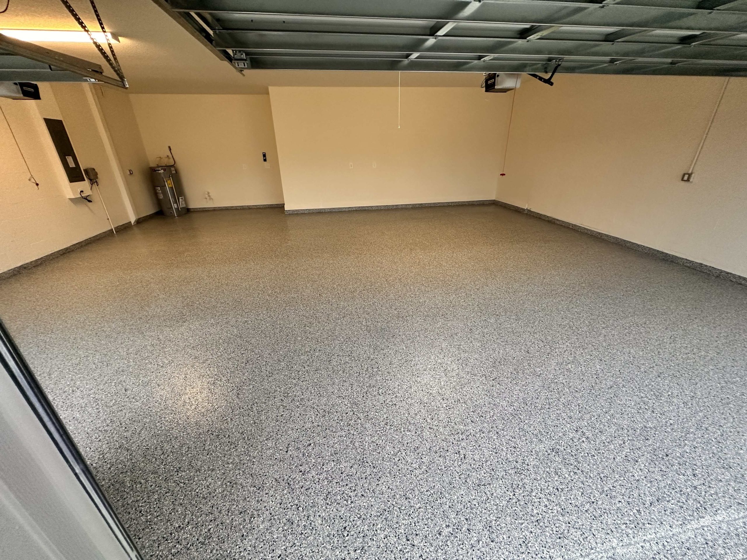 Finished epoxy garage floor with a smooth, speckled finish and clean wall edges.