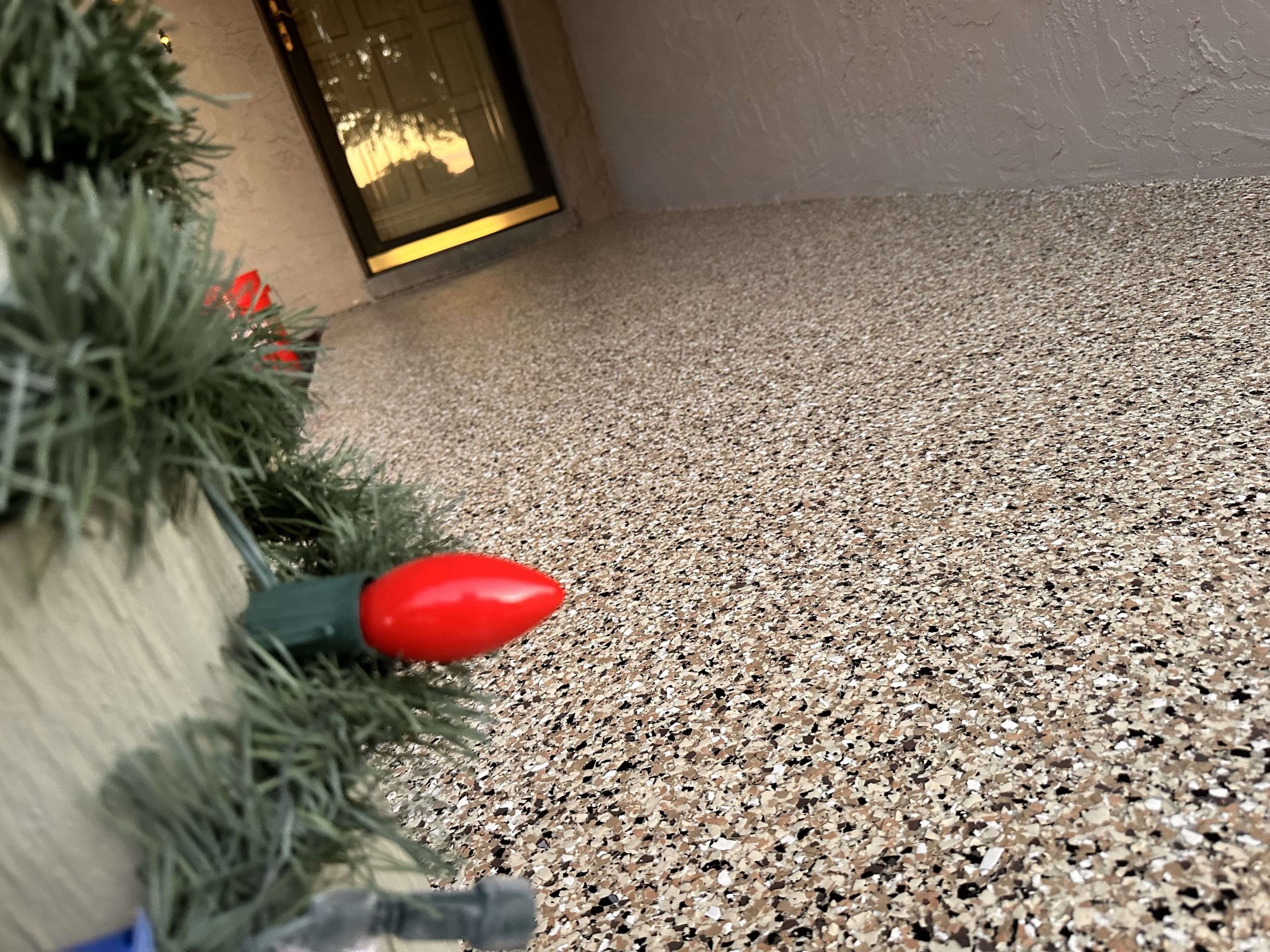 Epoxy-coated porch with tan, black, and white flake finish, taken at an angle