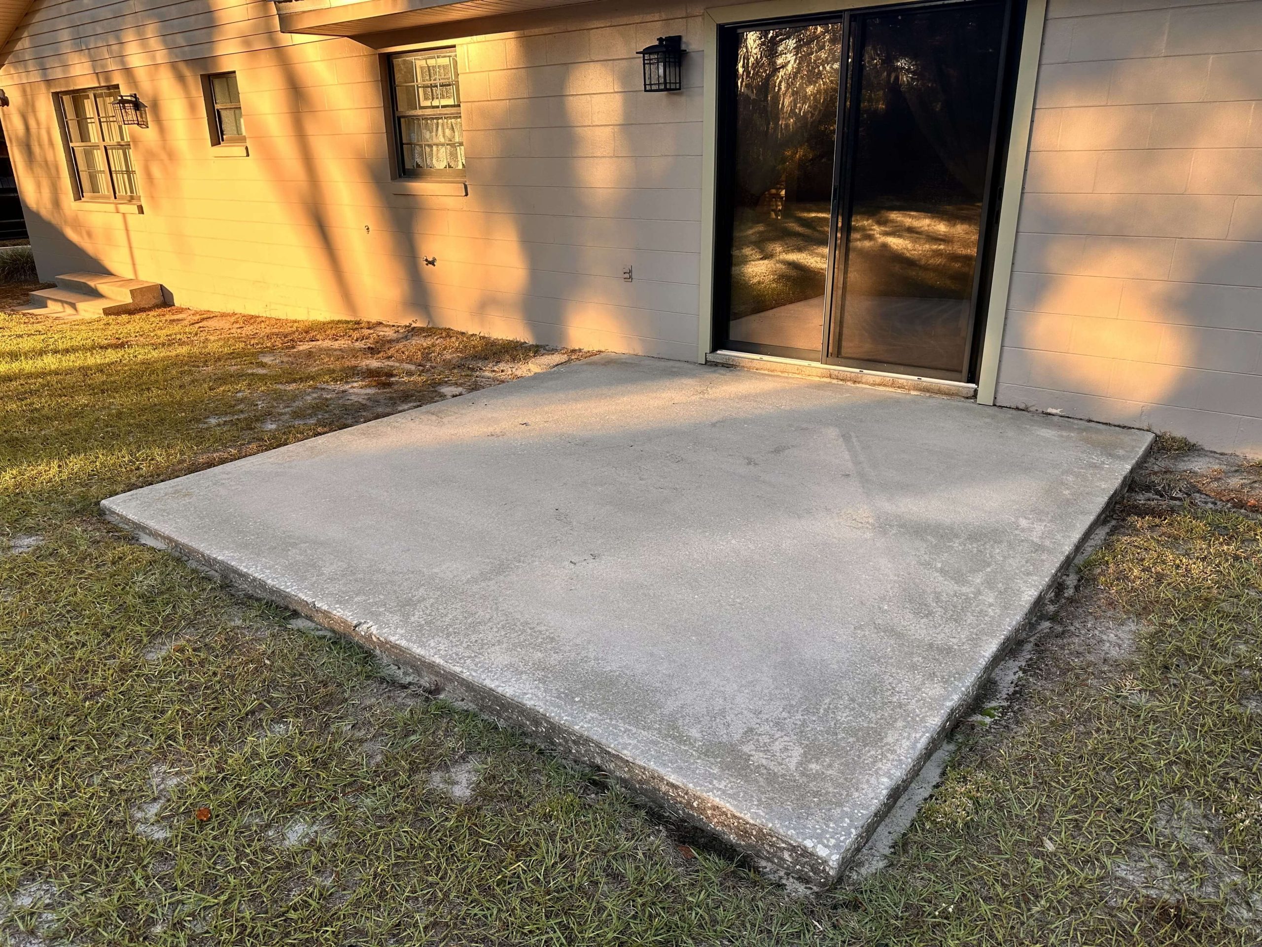 Unfinished concrete patio in backyard before epoxy coating.