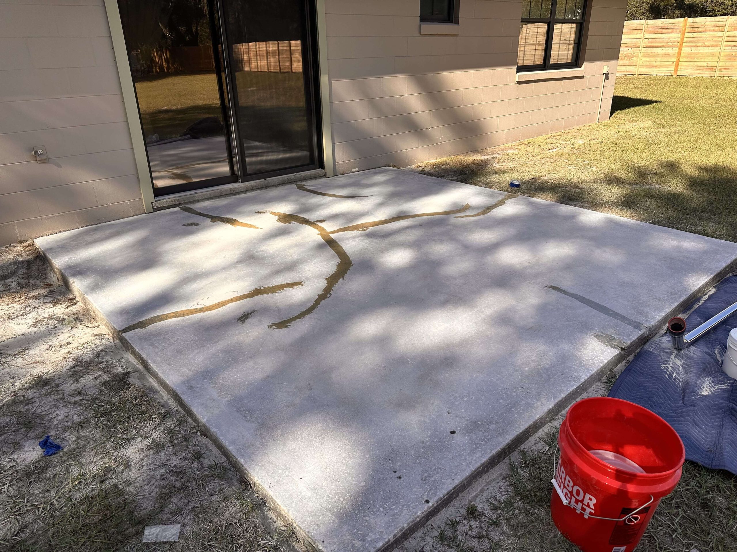 Cracked patio slab being repaired before epoxy coating.